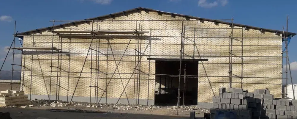 اتمام عملیات آجرچینی و بندکشی دیوار ضلع جنوبی سالن آغوزخانه در پروژه 6 هزار راسی ملایر